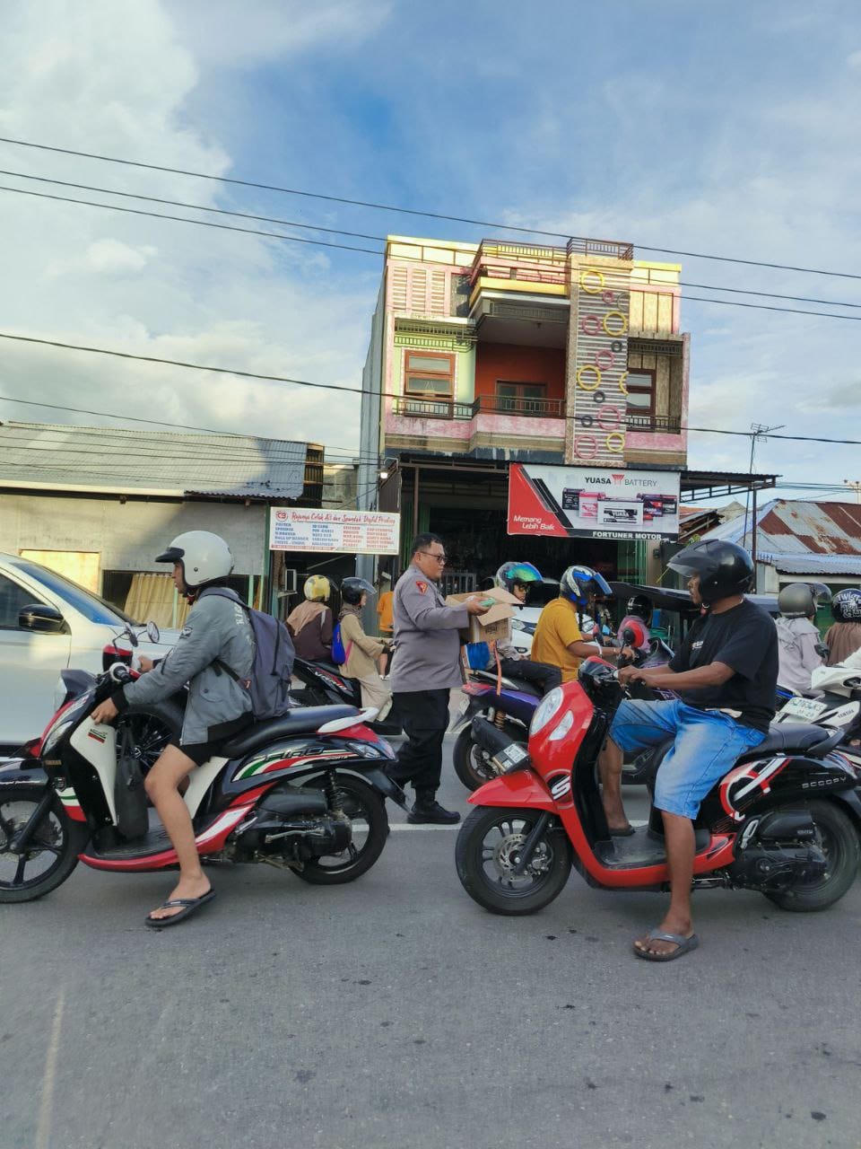 Aiptu Fredy Michael Tampi, S.H, S.Th, anggota Polri Polresta Gorontalo Kota. Saat membagikan takjil kepada warga ( Foto: Ist)