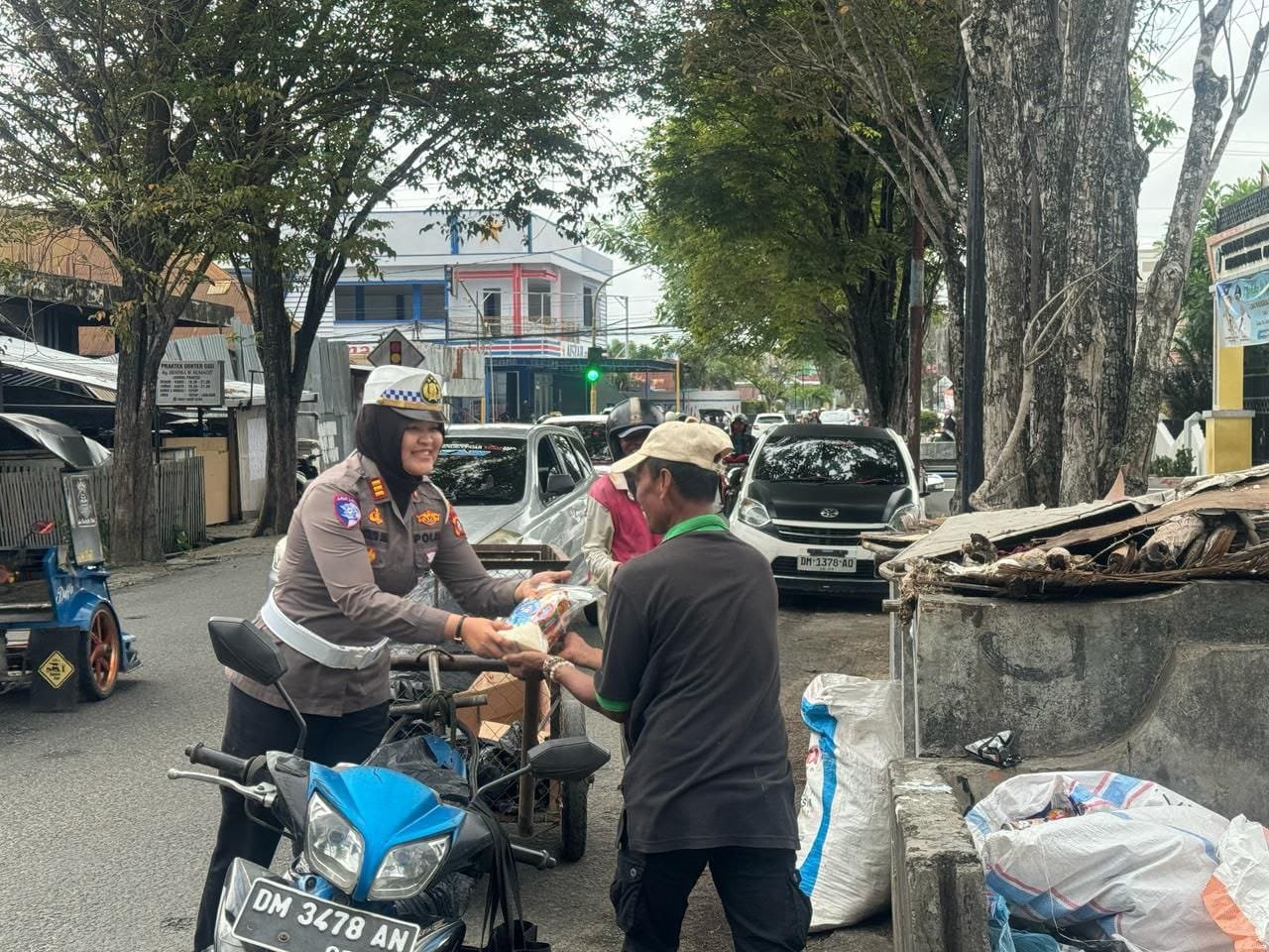 Kasat Lantas AKP Octalya Saka, S.Tr.K., S.I.K., M.Si., menggelar aksi sosial membagikan sembako kepada warga ( F. Hms)