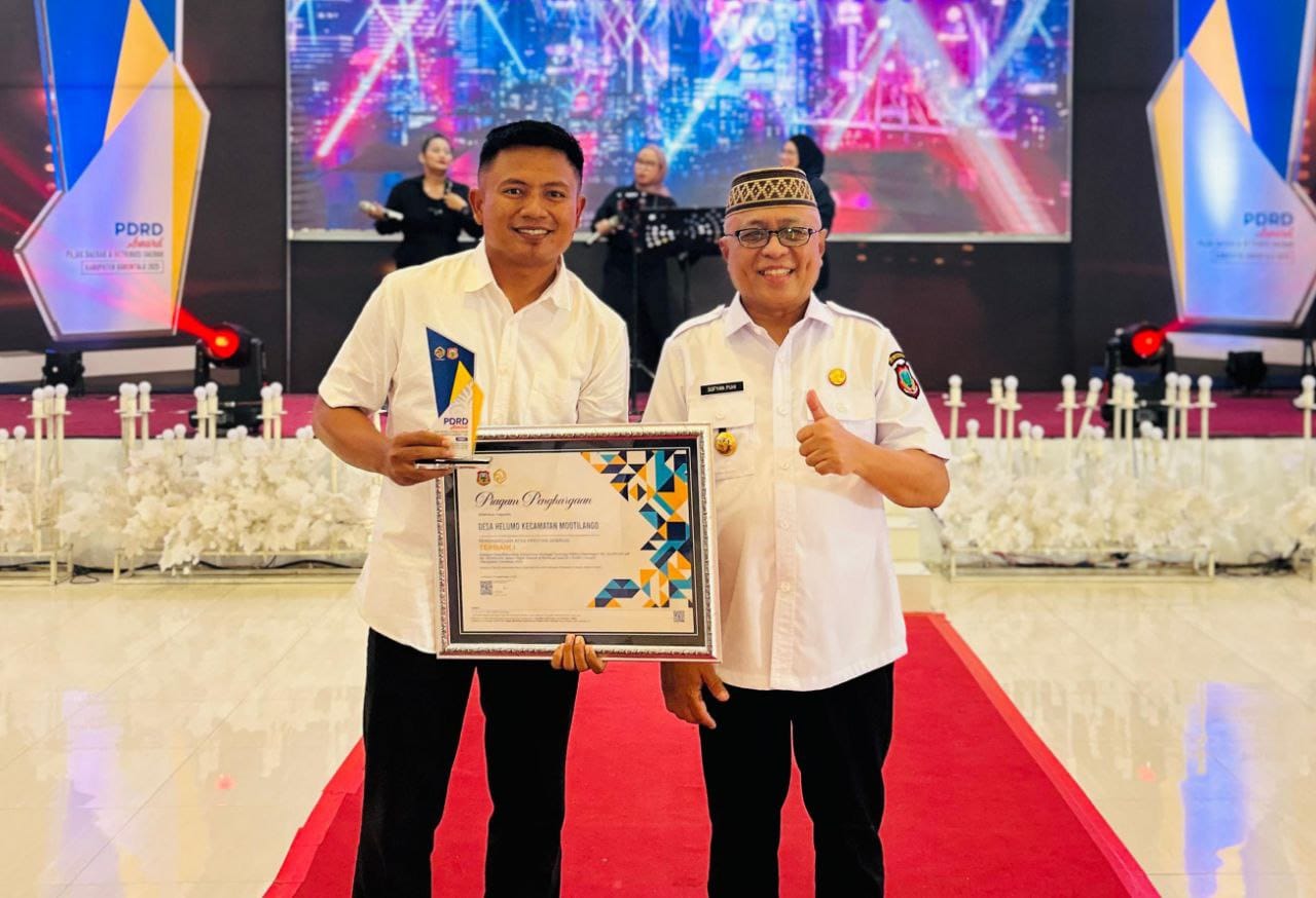 Kepala Desa Helumo, Habri Mahmud, S.Pd, menerima penghargaan PDRD Award