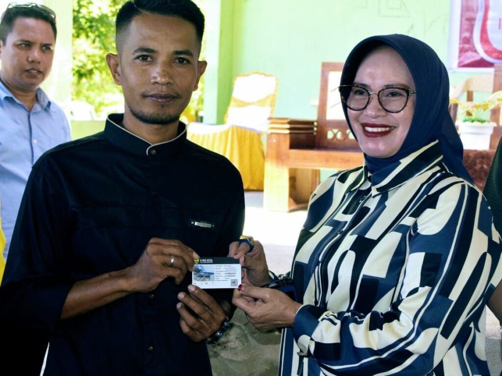 Ketua Tim Penggerak PKK Kabupaten Gorontalo, Ny. Maryam Sofyan Puhi, menyerahkan secara simbolis E-Pas Kecil (Surat Tanda Kebangsaan Kapal) kepada nelayan