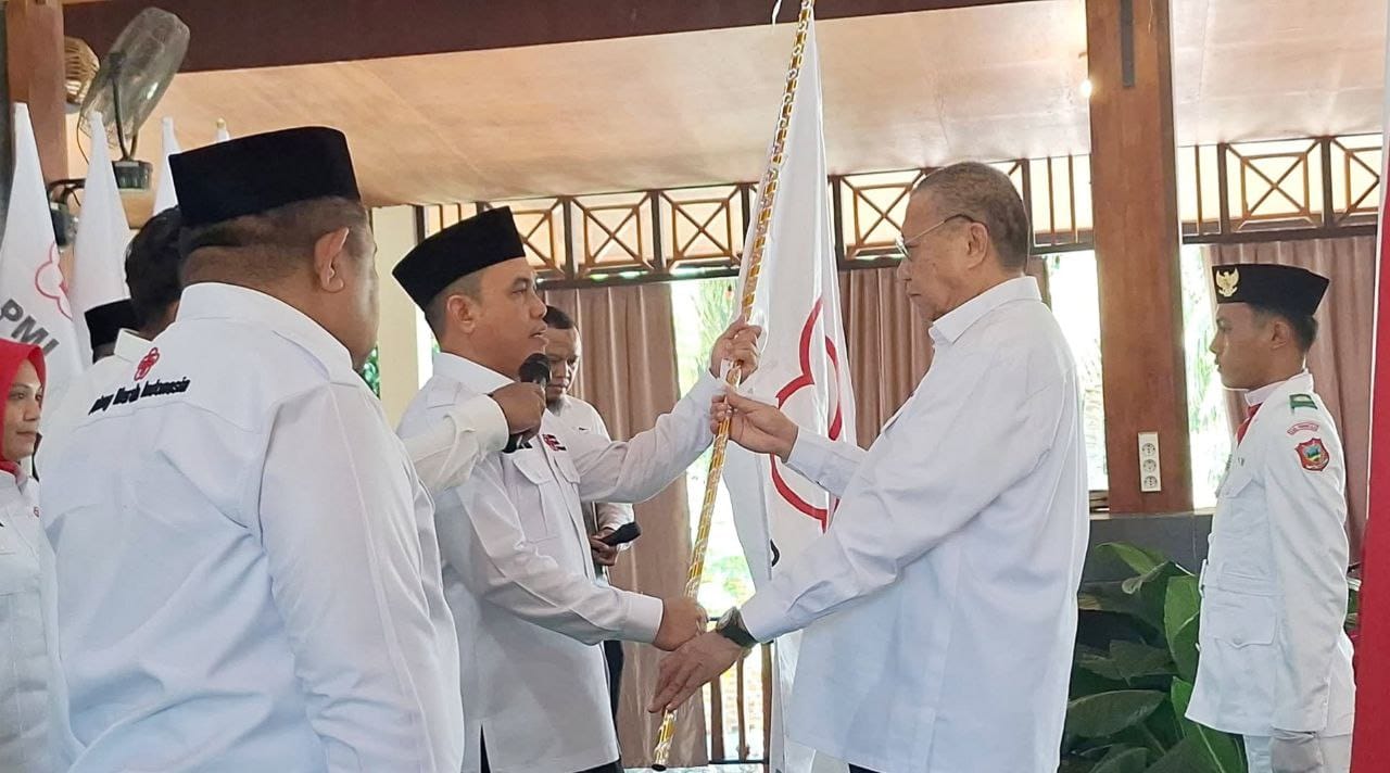ketua PMI Provinsi Gorontalo, Ishak Liputo saat Memberikan Pataka PMI Kepada Ketua PMI Kabupaten Gorontalo, Zulfikar A. Usira.