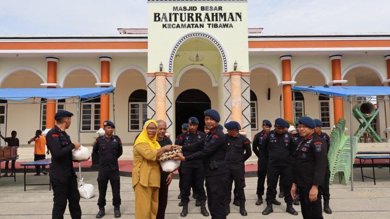Personel Sat Brimobda Gorontalo, saat menyerahkan bantuan sembako kepada pengurus Masjid Baiturrahman Kecamatan Tibawa, Jumat, 20/02/2026. (Foto : Humas)
